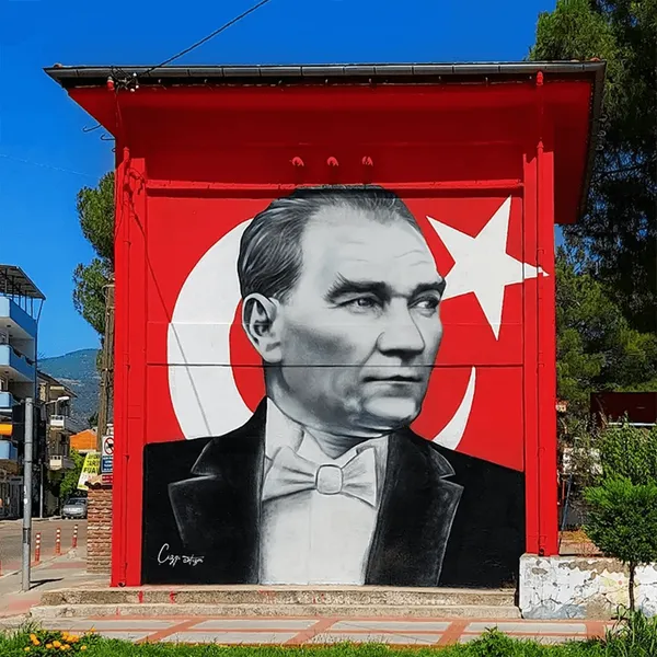 Kırmızı zeminde Türk bayrağı önünde siyah-beyaz Atatürk portresi trafo binası duvar resmi