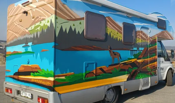 Karavan yüzeyine airbrush ile yapılmış dağ ve göl manzarası tasarımı