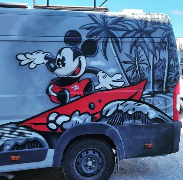 Minibüs yan yüzeyine airbrush ile yapılmış sörf yapan Mickey Mouse tasarımı
