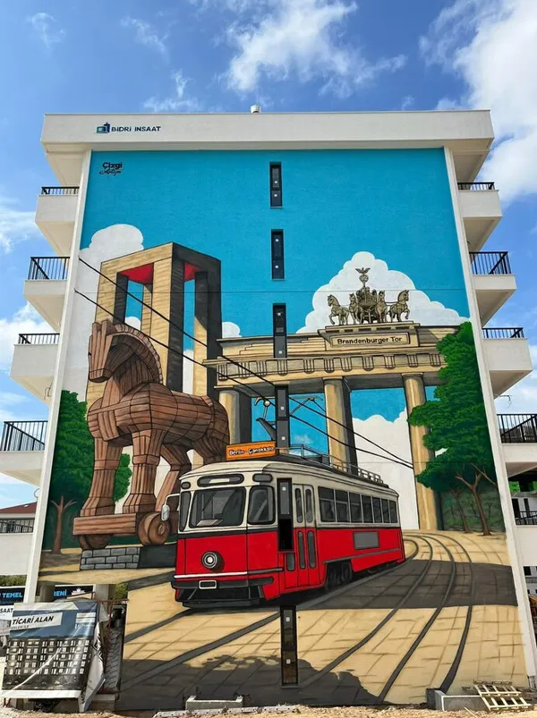 Bina cephesine yapılmış Truva atı, tramvay ve Brandenburg Kapısı temalı dev duvar resmi